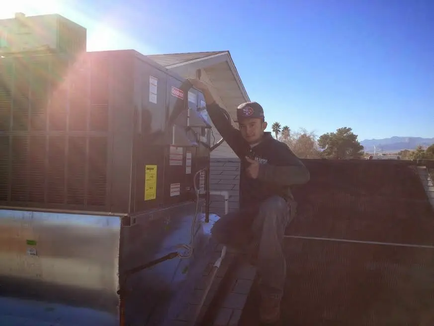 HVAC technician performing Heat Pump Repair on a rooftop unit in Crown Point